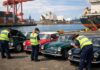 Australian Customs performing biosecurity checks on a shipment of classic cars at a shipping port in Sydney.