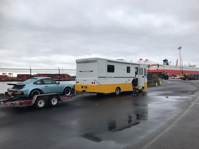 Porsche 911 Carrera Coupe on a trailer being delivered to the customers home.